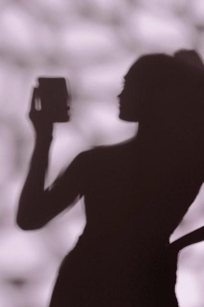 Photo silhouette of graceful woman taking a selfie