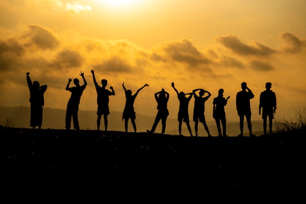 Foto la silhouette di un gruppo di persone sta celebrando il successo in cima alla collina.