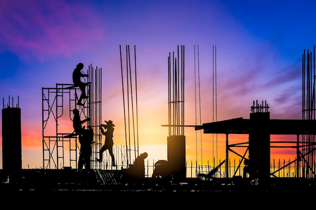 Silhouette group workers on building site with sunset sky in the evening