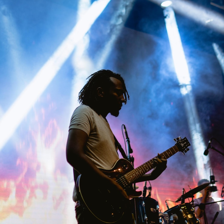 Photo silhouette of a guitar player on stage