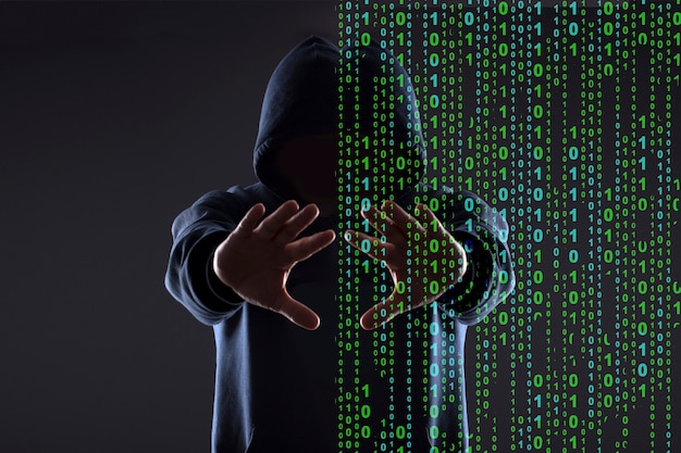 Silhouette of a hacker in the hood on a black background, concept  reality vs cyber space