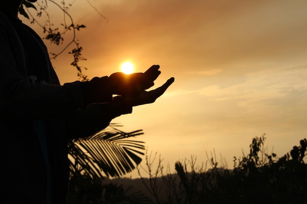 Фото Силуэт руки на небе во время захода солнца