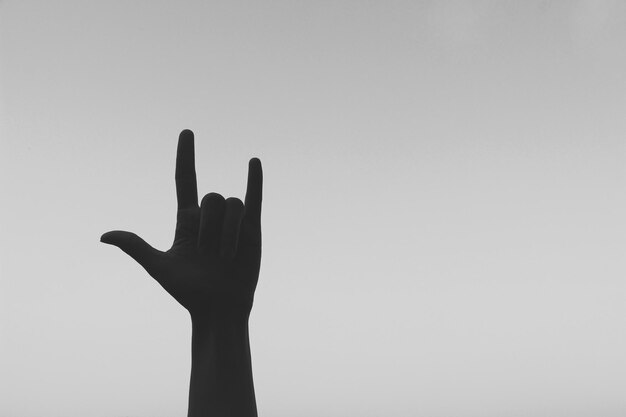 Photo silhouette of hand gesturing against sky