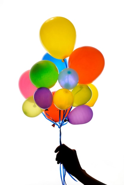 Photo silhouette hand holding balloons against white background