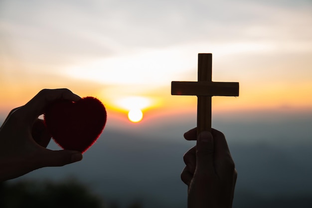 Foto silhouette mano che tiene il sole contro il cielo durante il tramonto