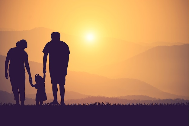 Silhouette di una famiglia felice e tramonto del tempo felice