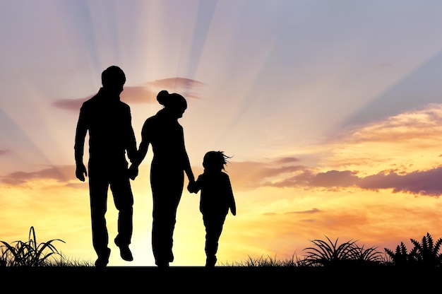 Foto silhouette di una famiglia felice con bambini sullo sfondo di un tramonto
