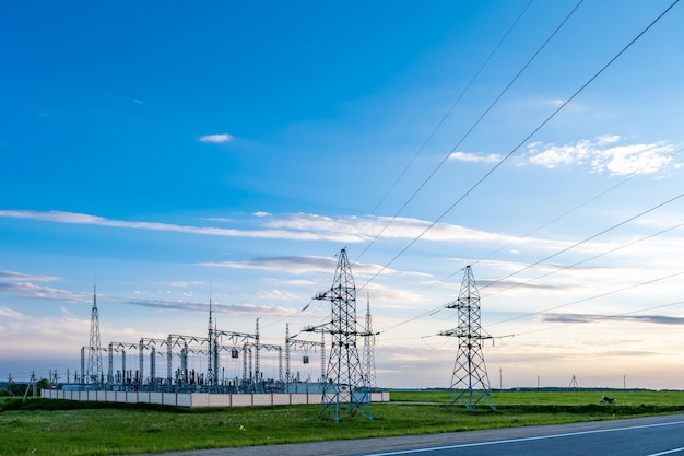 Silhouette of the high voltage electric pylon towers on the background of beautiful evening clouds