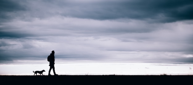 Silhouette of hiker and dog