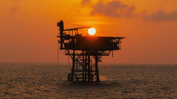 Photo silhouette a huge yellow of offshore oil rig drilling platform in the gulf in sunset process platform for production oil and gaspetroleum production and exploration industrial rc8 platform