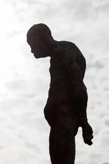 Photo silhouette of a human statue of stone