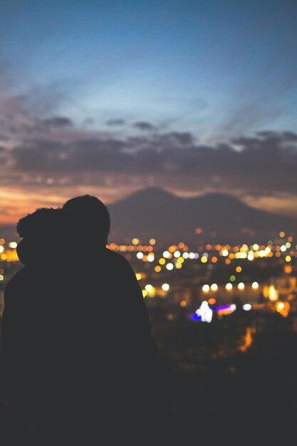 Foto silhouette di una città illuminata contro il cielo notturno