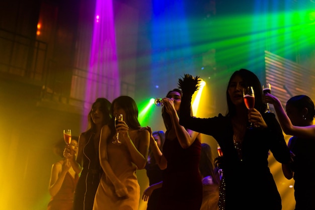 Silhouette image of people dance in disco night club to music\
from dj on stage