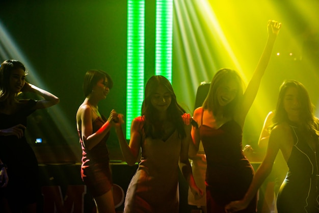 디스코 나이트 클럽에서 무대 위 DJ의 음악에 맞춰 춤추는 사람들의 실루엣 이미지