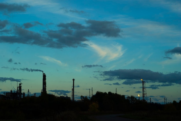 Silhouette industrial landscape with industrial torches and fractionating columns