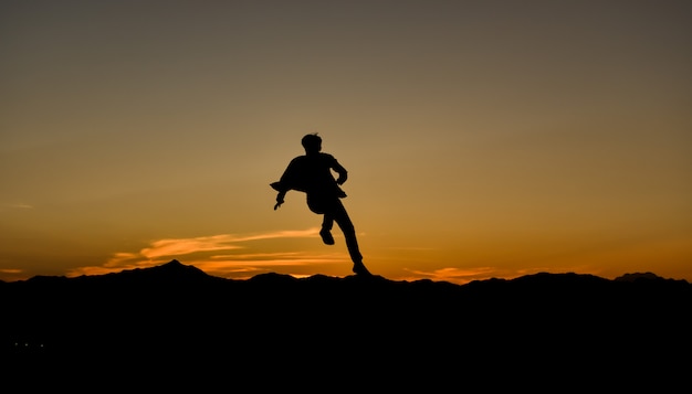 Silhouette of a jumping man at sunset