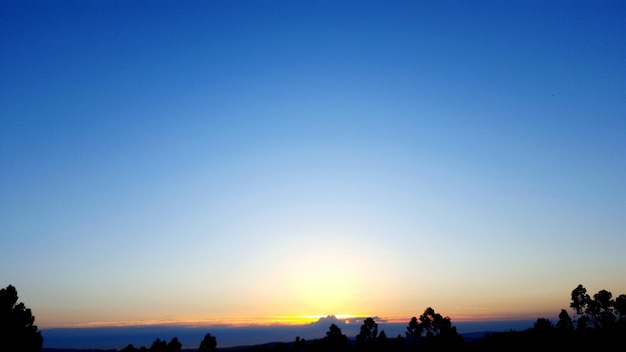 Silhouette landscape against clear sky during sunset