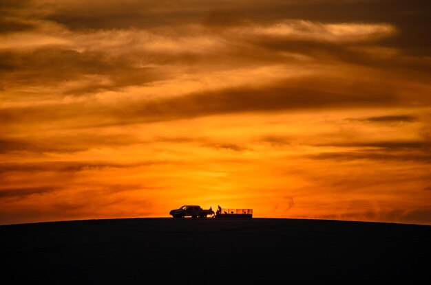 Photo silhouette landscape against dramatic sky during sunset