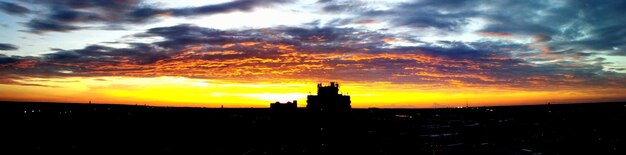 Silhouette landscape against scenic sky at sunset