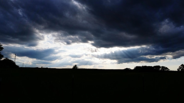 Photo silhouette of landscape under cloudy sky