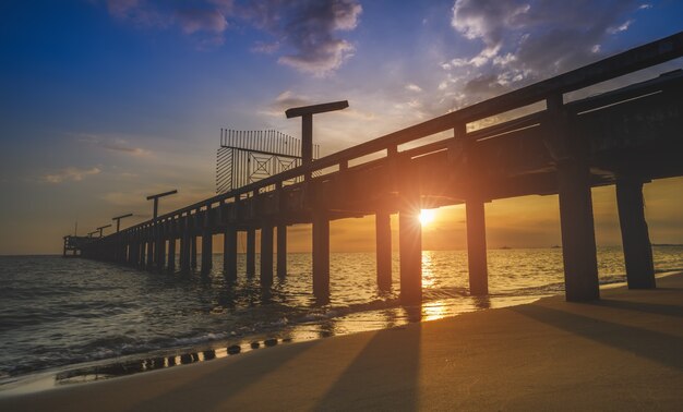 屋外の夕日の照明とシルエットの長い橋と空の海の風景。