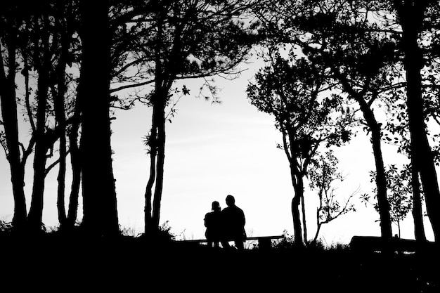 silhouette of love couple in trees border, back and white tone