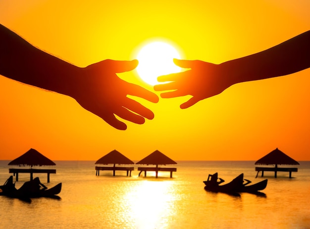 Silhouette of male and female hands against the backdrop of the setting sun