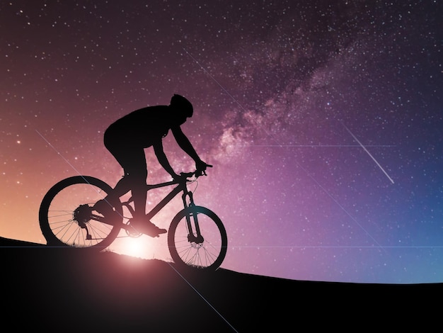 silhouette of a male tourist and his bike happiness and freedom in the evening the light is beautiful
