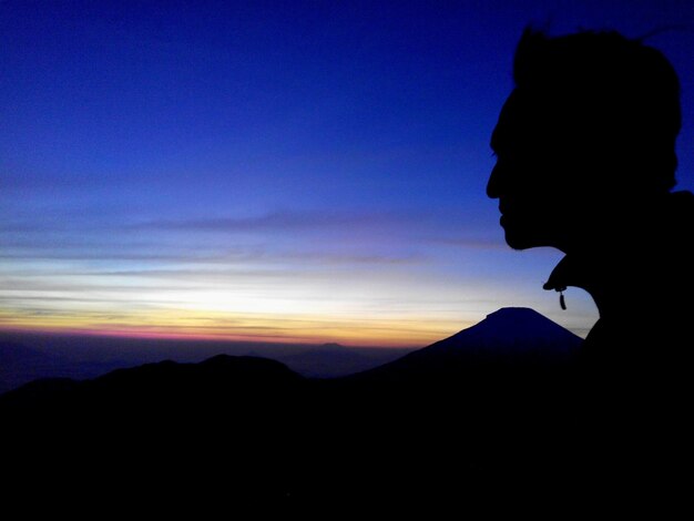 Foto silhouette uomo contro le montagne durante l'alba