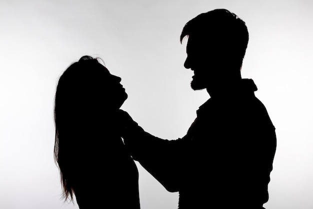 Silhouette of a man asphyxiating a woman.