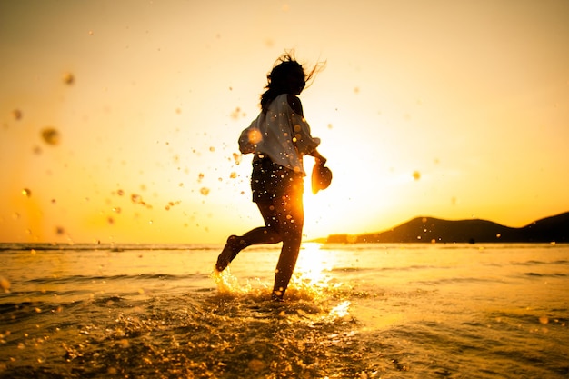 Photo silhouette man on beach against sky during sunset