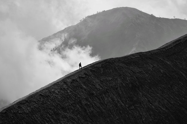 Foto silhouette uomo che si arrampica sulla montagna