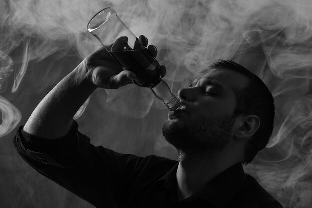 Silhouette of man drinking alcohol, close up