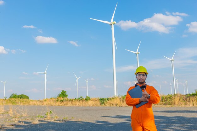 Силуэт человека-инженера, работающего и держащего отчет на ветряной турбине, электростанции на горе, люди в Таиланде