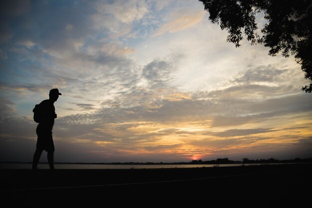 Silhouette of a man happy walking at sunset.