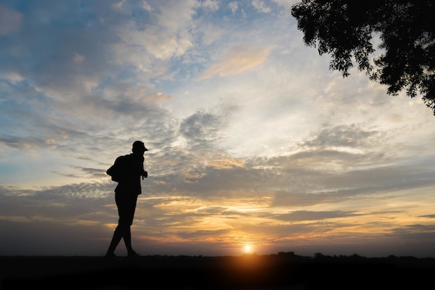 Silhouette of a man happy walking at sunset.