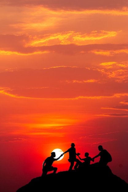 Silhouette of man hold up hands on the peak of mountain, success concept