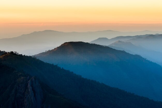 Silhouette of man hold up hands on the peak of mountain,success concept