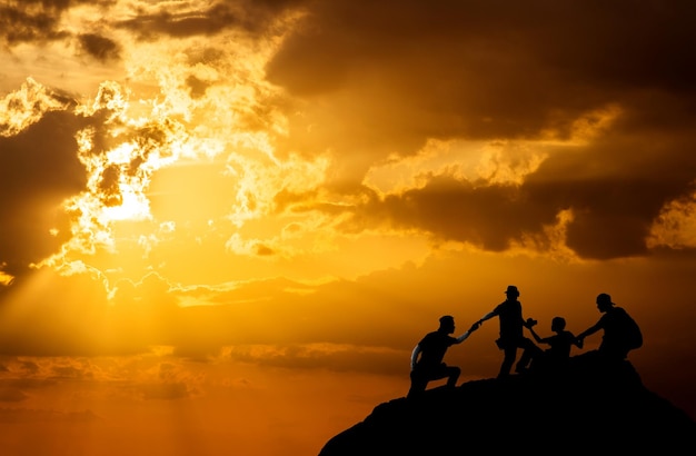 Silhouette of man hold up hands on the peak of mountainsuccess concept