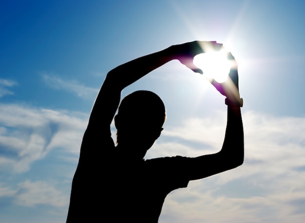 Silhouette of man holding the Sun