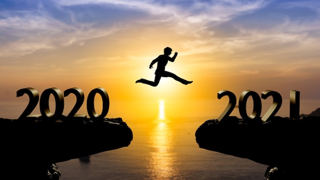 실루엣 남자는 일몰 벽, 2021 년 개념으로 2020 년에서 2021 년 사이에 점프