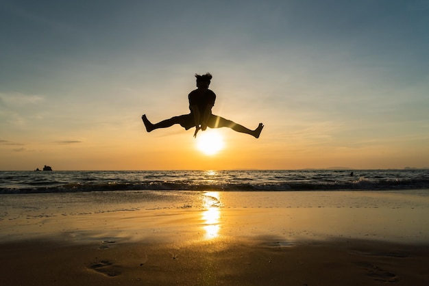 Silhouette man jump over sunset at phayam island ranong thailand