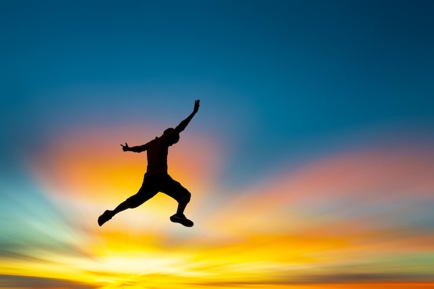 Silhouette man jumping against sky during sunset