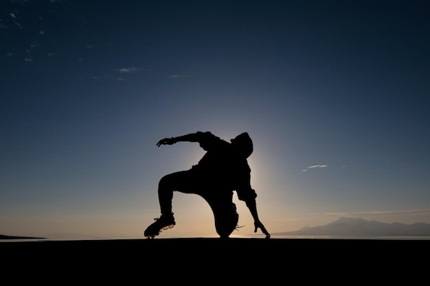 写真 夕暮れにジャンプするシルエットの男