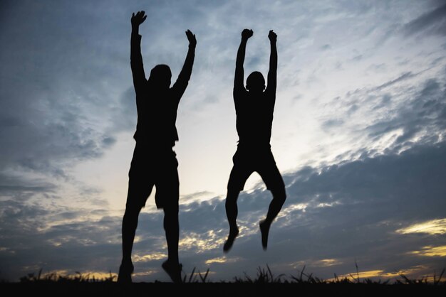 Silhouette of a man jumping with happy in the sunset.