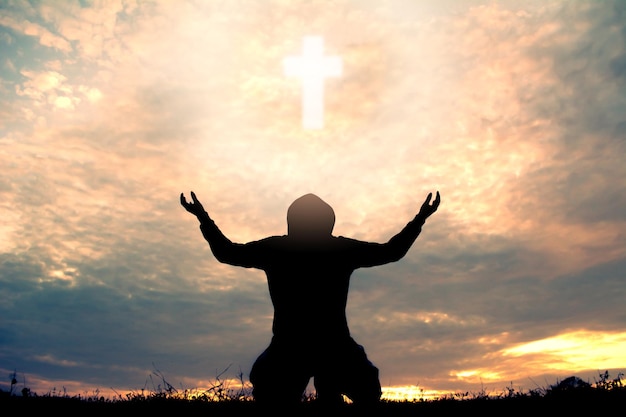 silhouette man kneeling against sky during sunset