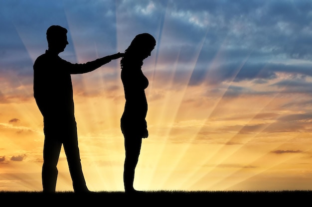 A silhouette of a man morally supports a sad woman. The concept of support and help to people