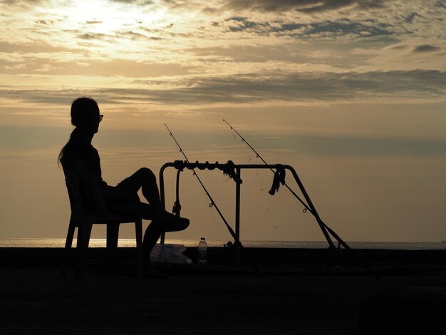 写真 夕暮れの空に照らされたビーチのシルエット男