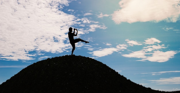 Silhouette man one leg stand and kicking