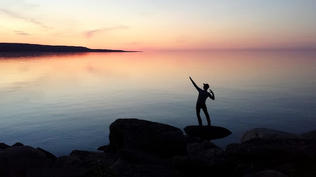 Photo silhouette man overlooking calm sea